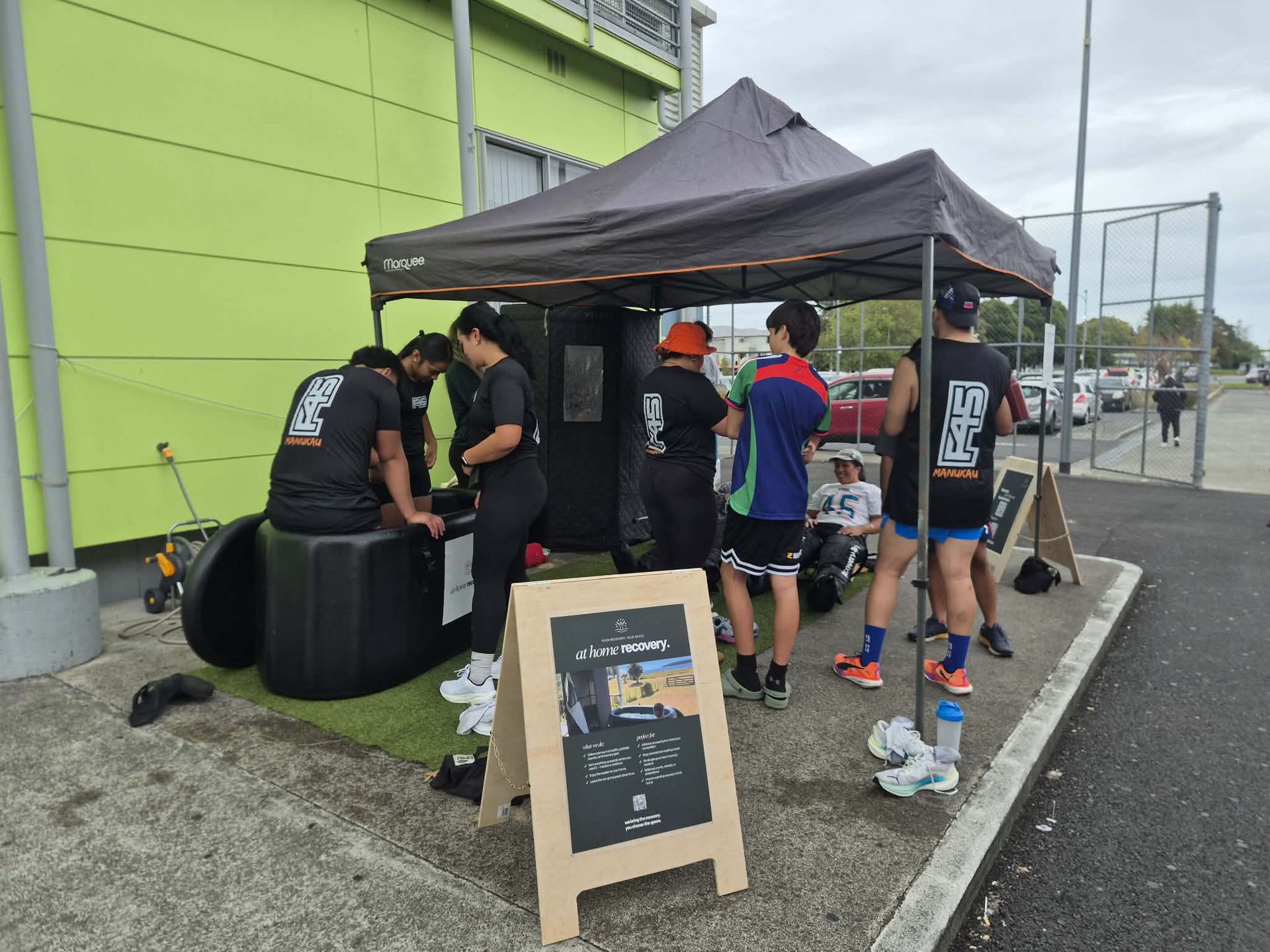 A busy recovery zone with an ice bath and boots in use